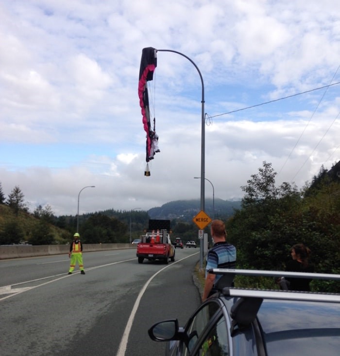  A paraglider is seen dangling from a lamppost over a lane of Highway 99 in Squamish on Tues. Sept 10, 2019. Photo submitted/via The Squamish Chief