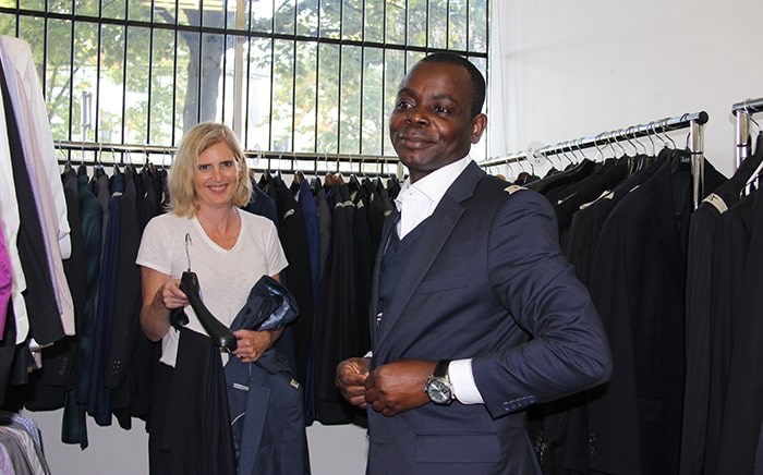  Joan Glover helps client Michael Olabode pick out a suit. Photo: Elisia Seeber