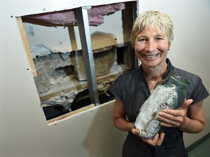  Shaughnessy elementary principal Janet Souther holds the emptied 100-year-old time capsule in front of where it was extracted. Photo Dan Toulgoet