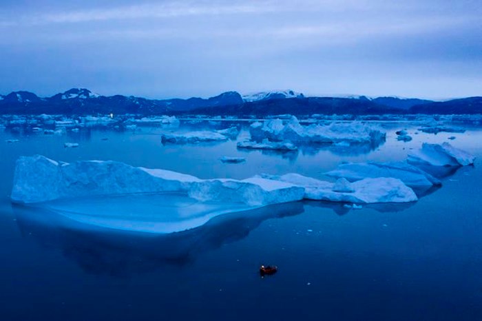  In this Aug. 15, 2019, photo, a boat navigates at night next to large icebergs near the town of Kulusuk, in eastern Greenland. An international scientific body says the damage to earth's oceans and glaciers from climate change is now outpacing the ability of governments to protect them. THE CANADIAN PRESS/ AP/Felipe Dana