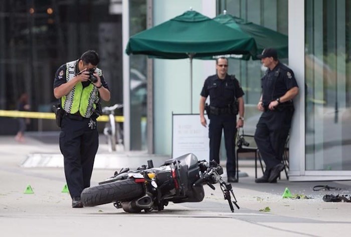  A police officer photographs a motorcycle after a female stunt driver working on the movie 