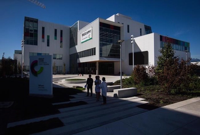  People stand outside the new Emily Carr University of Art and Design campus in Vancouver, B.C., on Friday September 1, 2017. A Vancouver man has been arrested and charge with breaking and entering and arson on the campus. THE CANADIAN PRESS/Darryl Dyck