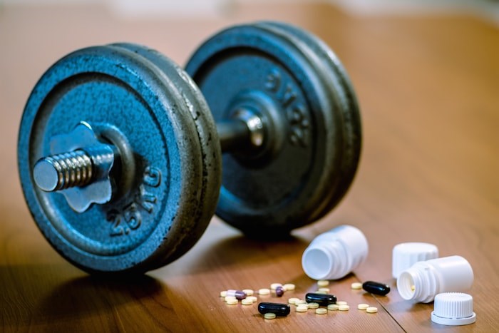  A North Vancouver bodybuilder has been fined just under $140,000 and placed under house arrest for four months as part of his sentencing in a steroids trafficking case. Photo: Steroid pills and weights/Shutterstock