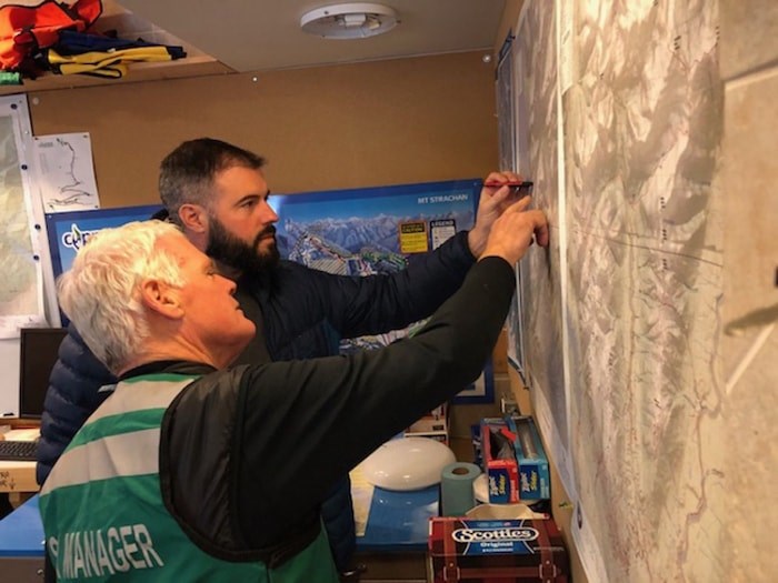  North Shore Rescue search manager Peter Haigh and member Philippe LaPoint look over a map at the Cypress Mountain command base in West Vancouver Thursday morning. Searchers from Lions Bay and the North Shore have been combing the backcountry after a 25-year-old hiker went missing from the Howe Sound Crest Trail Wednesday afternoon. photo Mike Wakefield, North Shore News.