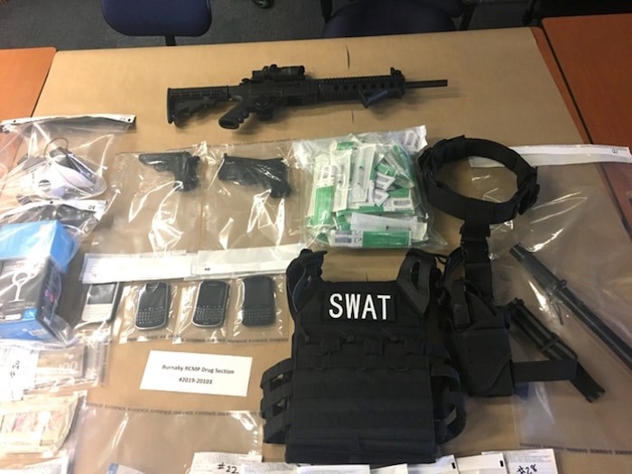  Police seized drugs, cash, fake handguns and a fully operational semi-automatic rifle at raids on two residences in Burnaby and Maple Ridge Wednesday. Photo courtesy Burnaby RCMP