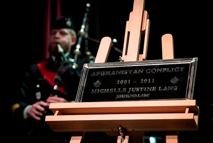  A plaque honouring Calgary Herald journalist Michelle Lang, who was killed while working in Afghanistan in 2009, is unveiled as Sgt. Daniel Bell, of the Seaforth Highlanders of Canada, plays bagpipes during a Remembrance Day ceremony at her high school, Magee Secondary School, in Vancouver, on Thursday November 7, 2019. Lang, 34, and four Canadian soldiers died when the armoured vehicle they were traveling in struck an improvised explosive device on the outskirts of Kandahar. THE CANADIAN PRESS/Darryl Dyck