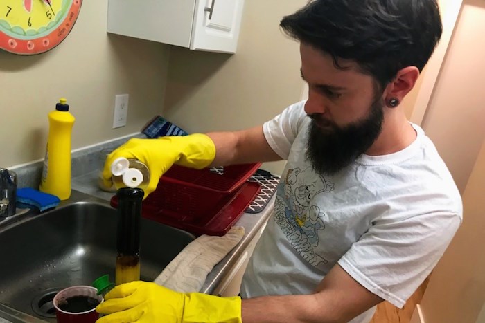  Robinson uses an environmentally friendly glass cleaner, to scrub out the bongs. Photo by Eric Thompson