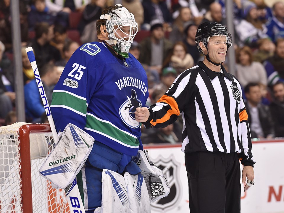 Jacob Markstrom shares a moment with a referee in the Canucks net.