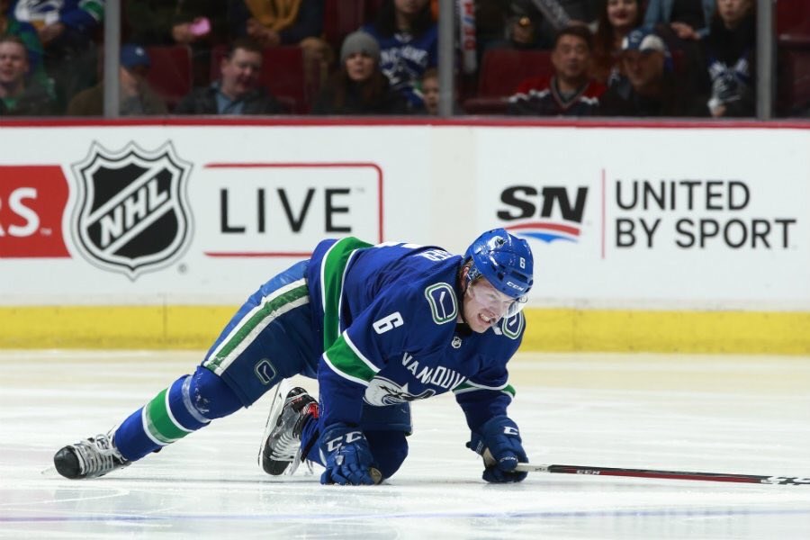Brock Boeser crawls to the bench after blocking a shot with his left foot.