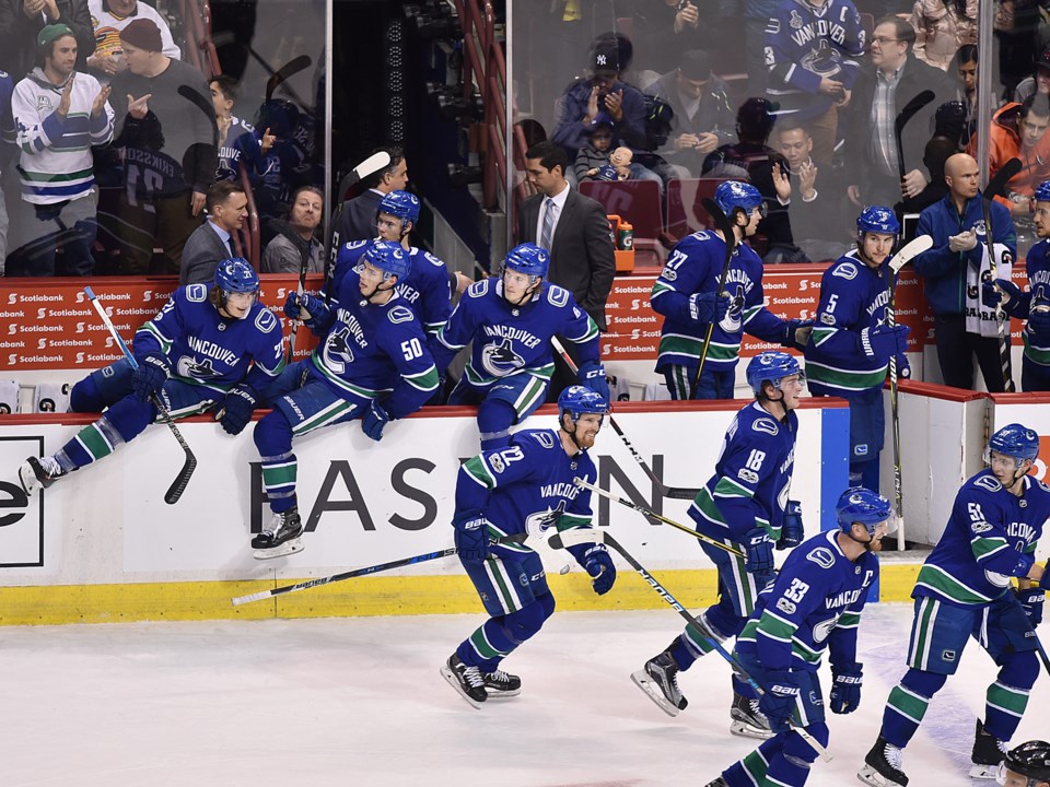 The Canucks stream over the boards to congratulate Jacob Markstrom on his first career NHL shutout.