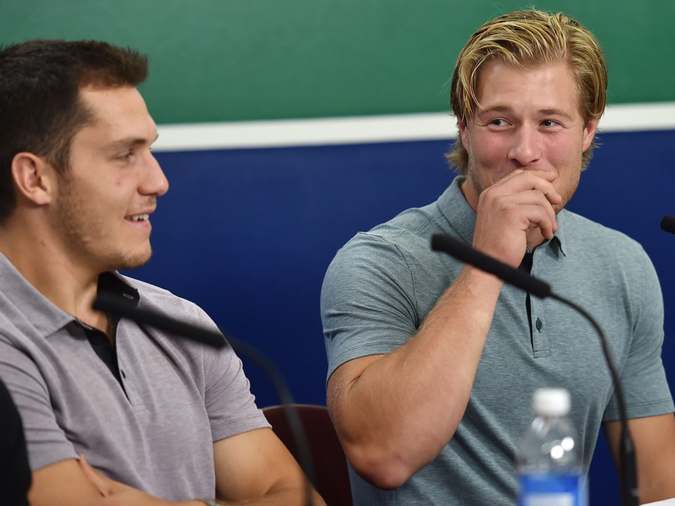 Brock Boeser laughs with Bo Horvat while talking to the media before training camp.