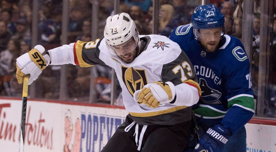 Brandon Pirri of the Vegas Golden Knights checks Alex Edler of the Vancouver Canucks