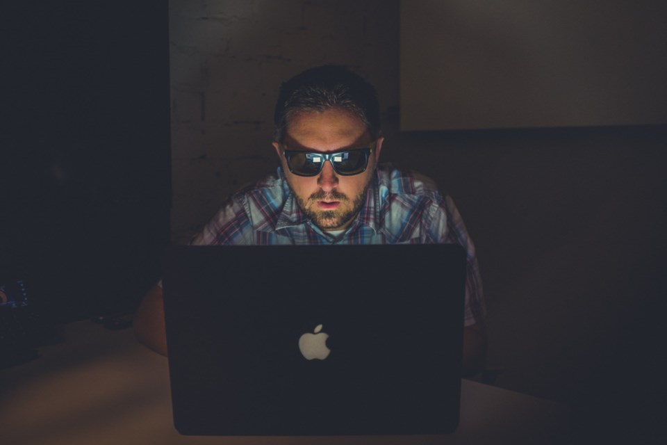 Man at a laptop with sunglasses on