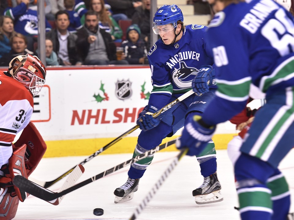 Jake Virtanen holds off a check as he carries the puck for the 鶹ýӳCanucks.