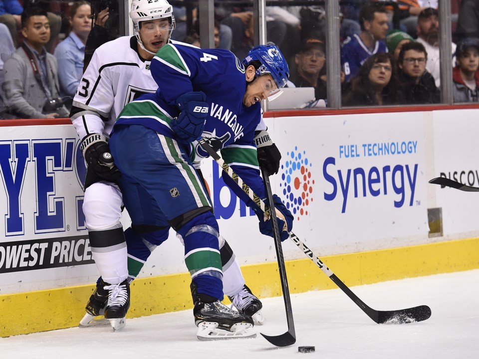 Michael Del Zotto battles with Dustin Brown for the puck for the Vancouver Canucks