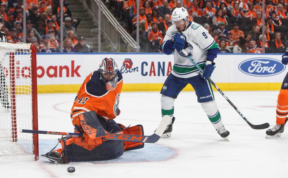 The 鶹ýӳCanucks' J.T. Miller looks on as Mike Smith of the Edmonton Oilers makes a save