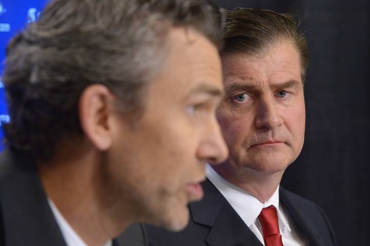 Jim Benning stares at Trevor Linden disconcertingly.