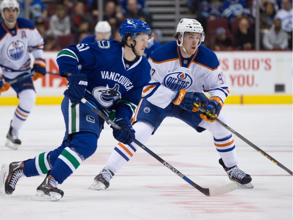 Jared McCann skates alongside Connor McDavid