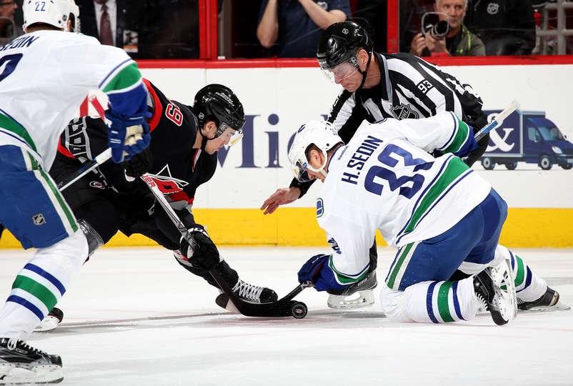 Henrik Sedin takes a faceoff