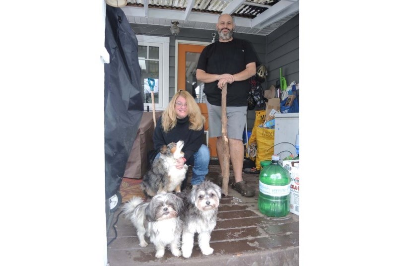 Leanne Taylor and Shane Alexander, with their three dogs which were attacked on this patio last week by a family of four raccoons. Photo by Alan Campbell/Richmond News