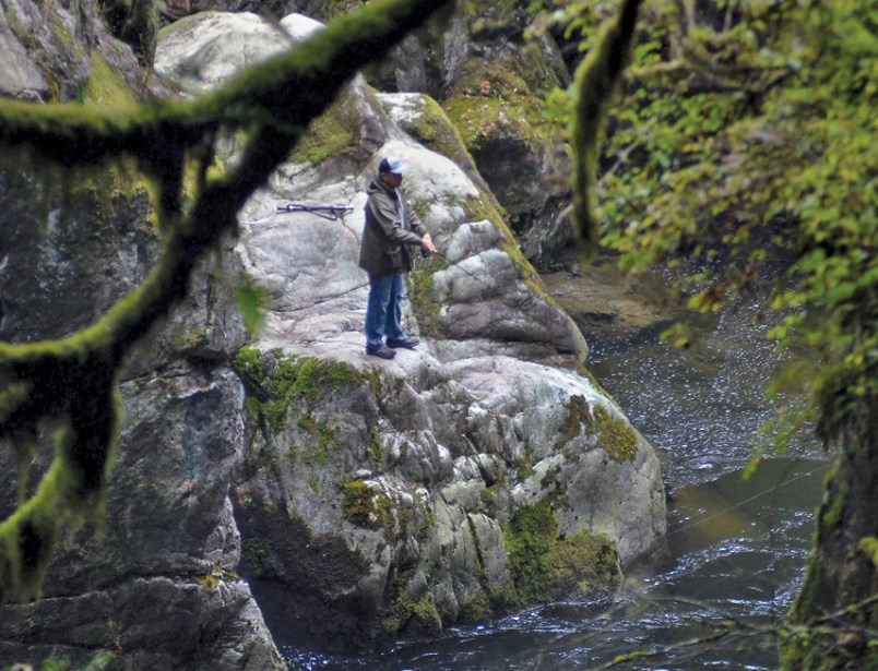 An angler casts his line in the Capilano River in the days after the 2020 Cleveland Dam tragedy. / Paul McGrath, North Shore News files.