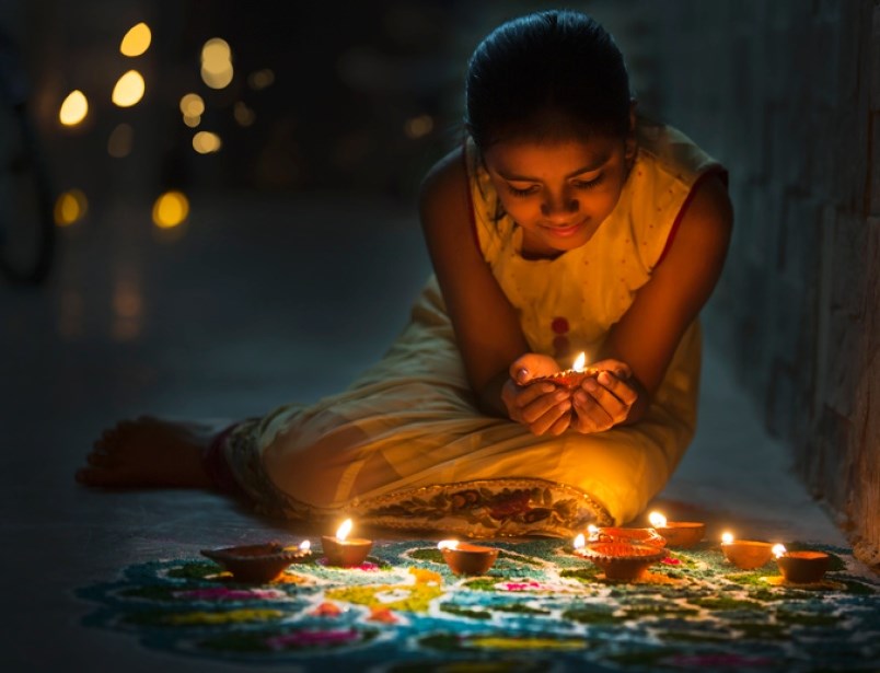 a-girl-lights-diya-clay-lanterns-during-diwali-the-hindu-celebration-of-light