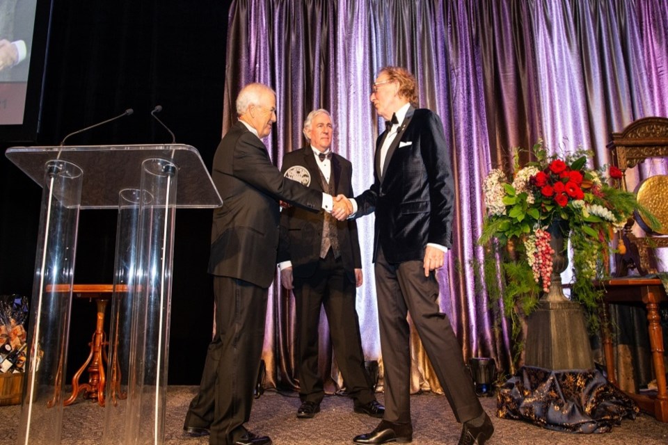 Anthony von Mandl (right) on stage to receive his award. Left: Peter Gustavson, Chair of DEYA selection committee. Middle: Saul Klein, Dean of the Gustavson School of Business.