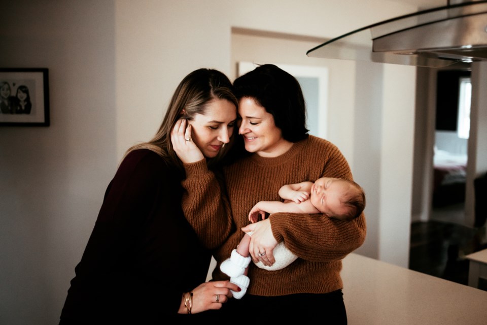 Amanda and Sarah with baby Theodore at their home. 