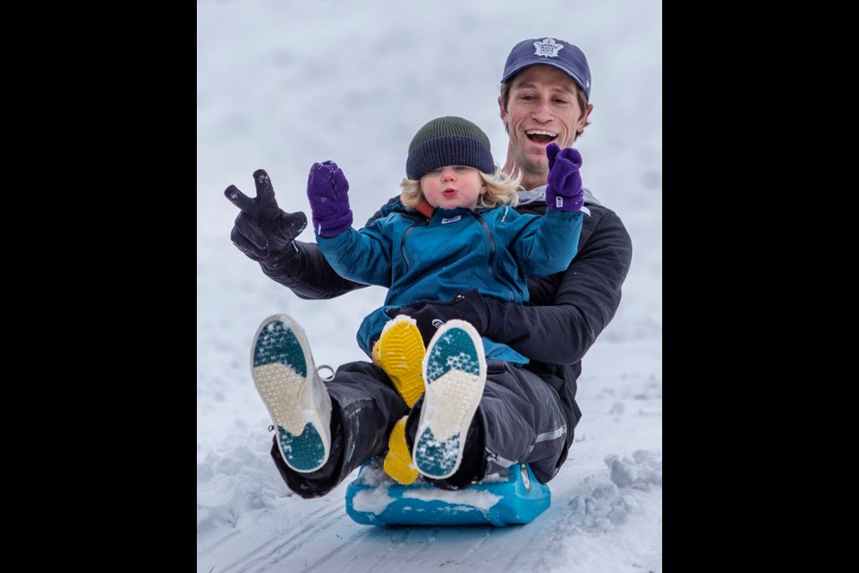Andrew Murdoch and his 18-month-old son, Rory Murdoch, slide down Beacon Hill near Dallas Road, on Wednesday, Jan. 17, 2024. DARREN STONE, TIMES COLONIST