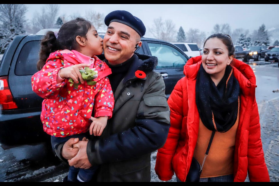 Evacuated residents from Merritt, B.C., Barkad Khan, centre, holds his daughter Mahira Khan, 4, as his wife Afreen Khan, looks on while they gather at a reception centre in Kamloops, B.C., Thursday, Nov. 18, 2021. THE CANADIAN PRESS/Jeff McIntosh