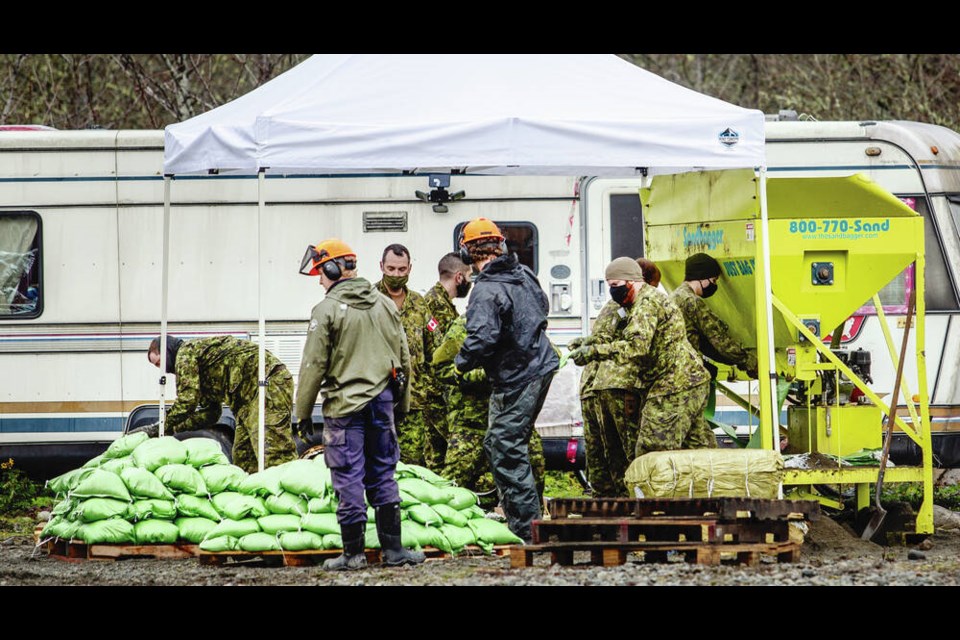 Canadian soldiers help to fill sandbags at the Clem Clem Longhouse in Duncan on Tuesday. DARREN STONE, TIMES COLONIST 