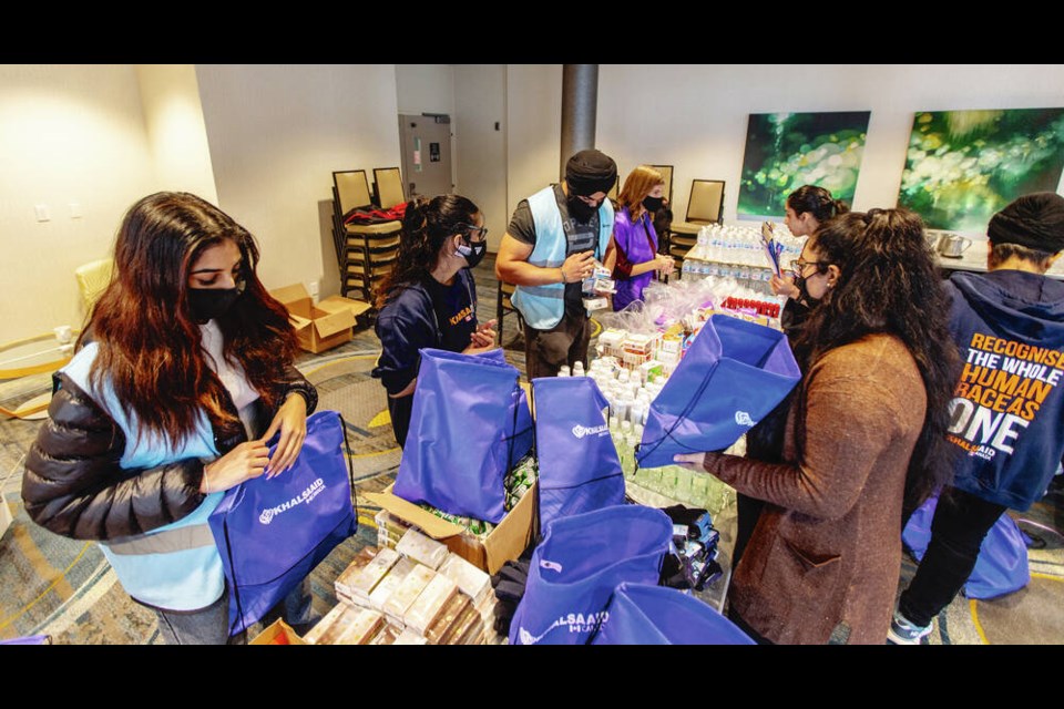 Khalsa Aid volunteers prepare hygiene care packages at the Delta Ocean Pointe Resort in Victoria on Saturday. DARREN STONE, TIMES COLONIST 
