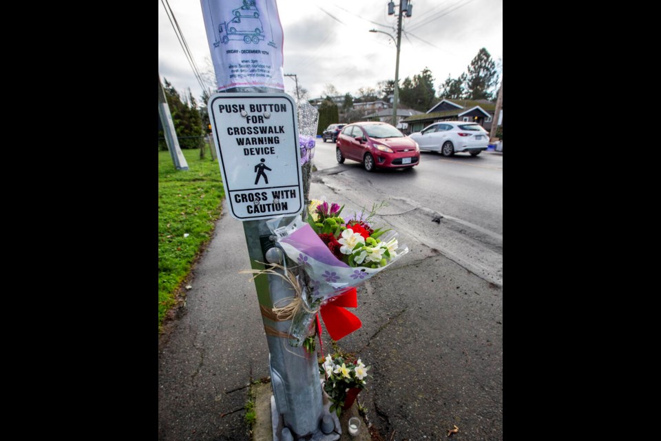 Flowers attached to a pole at the Cedar Hill Cross Road crosswalk where Reynolds Secondary School student Kaydence Bourque was struck and killed Monday night. ADRIAN LAM, TIMES COLONIST 