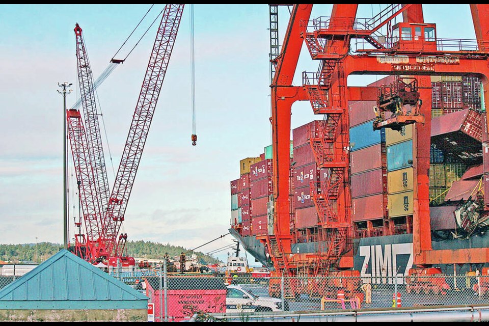 Crews remove containers from the Zim Kingston at Port of Nanaimo. So far, about 11 containers have been lifted from the vessel, which sat for weeks off Victoria after losing part of its load in heavy seas, and then enduring a fire that damaged some containers. MARTIN LEDUC  