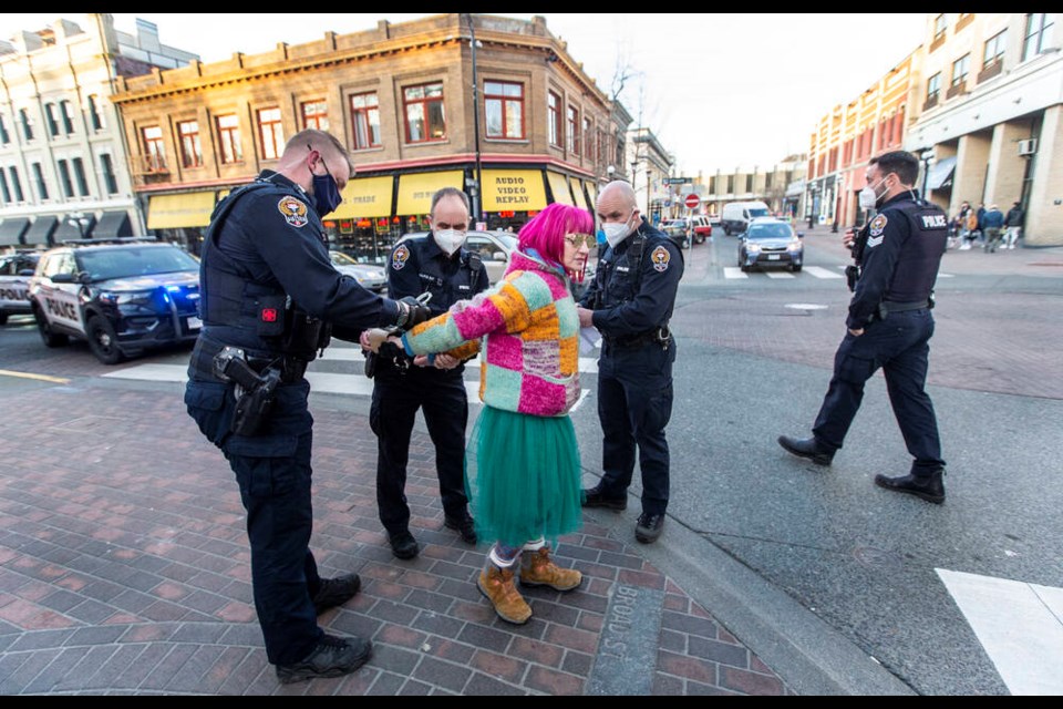 A woman is arrested for stopping cars from travelling down Broad Street during an old-growth logging protest in downtown Victoria on Friday, Jan. 28, 2022. DARREN STONE, TIMES COLONIST
