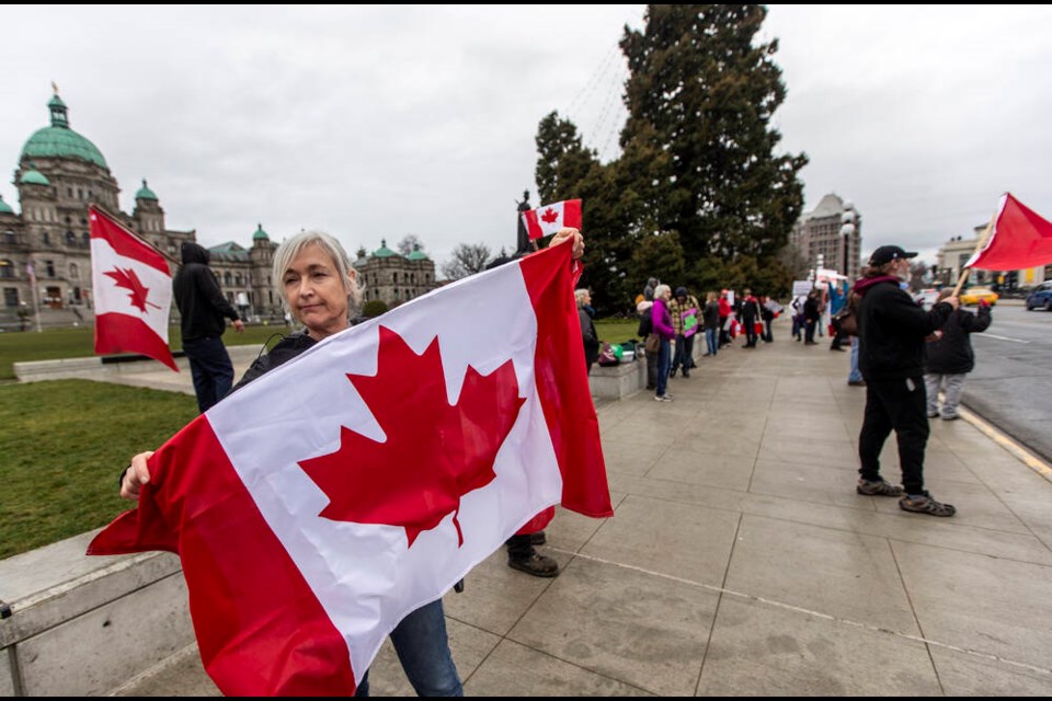 Dr. Anna Kindy of Campbell River holds a flag after joining a vaccine-mandate protest at the B.C. legislature on Tuesday, Throne Speech day. DARREN STONE, TIMES COLONIST 