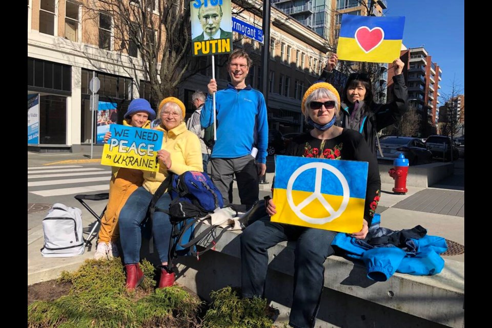Marina Gadbois, left, with her grandmother Olga Lang, friends Greg Glover and Misuzu Kurauchi, and fellow demonstrator Pati-Ann Lawe at a rally in support of the people of Ukraine along Douglas Street in Greater Victoria on Sunday, March 6, 2022. TIMES COLONIST