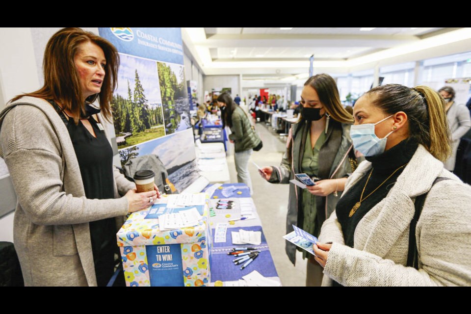 Paula Blazina, left, with Coastal Community Credit Union, talks with second-year business administration student Melissa Rojas, centre, and Janis Rodriguez at Hiring Day Monday at the University of Victorias Student Union Building. ADRIAN LAM, TIMES COLONIST 