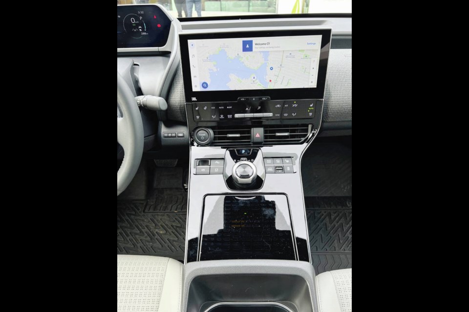 The centre console of the 2023 Toyota bZ4X showing the 12.3-inch touch-screen multimedia system that is Over-The-Air upgradeable and an Intelligent Assistant that responds to commands of Hey Toyota to change channels, call friends or turn up the heat. A covered cubby-hole, located behind the rotary gear changer, includes a Qi-wireless charger for cellphones in some models. Credit Pedro Arrais 