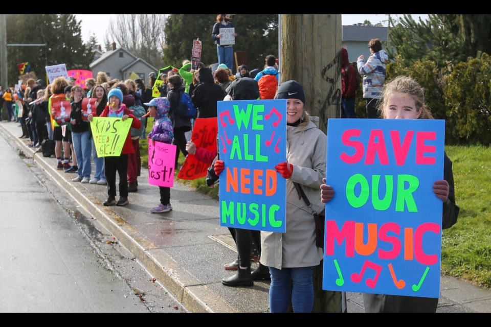Students and parents protest proposed cuts to music programs, custodians and counsellors in front of the Greater Victoria School District offices on Boleskine Road on Monday. ADRIAN LAM, TIMES COLONIST 