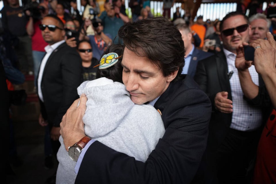 Prime Minister Justin Trudeau hugs a residential school survivor as he arrives for a ceremony marking the one-year anniversary of the Tk’emlúps te Secwépemc announcement of the detection of the remains of 215 children at an unmarked burial site at the former Kamloops Indian Residential School, in Kamloops, B.C., on Monday, May 23, 2022. THE CANADIAN PRESS/Darryl Dyck