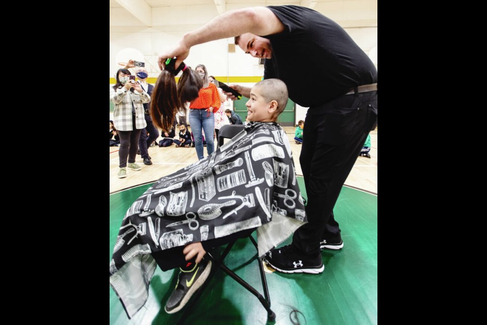 Barber Burt Hill shows Thomas Joe his hair after cutting it. DARREN STONE, TIMES COLONIST 