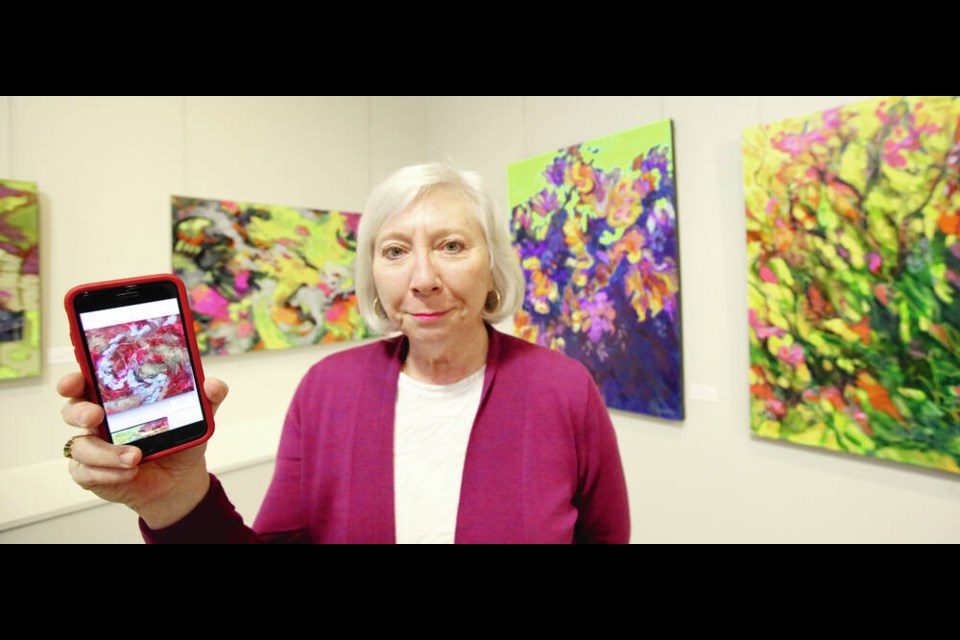 Christine Reimer, at the Cedar Hill Recreation Centre gallery, holds a photo of the art piece titled All that Glitters, which was stolen last week after it was hung for a show. ADRIAN LAM, TIMES COLONIST 