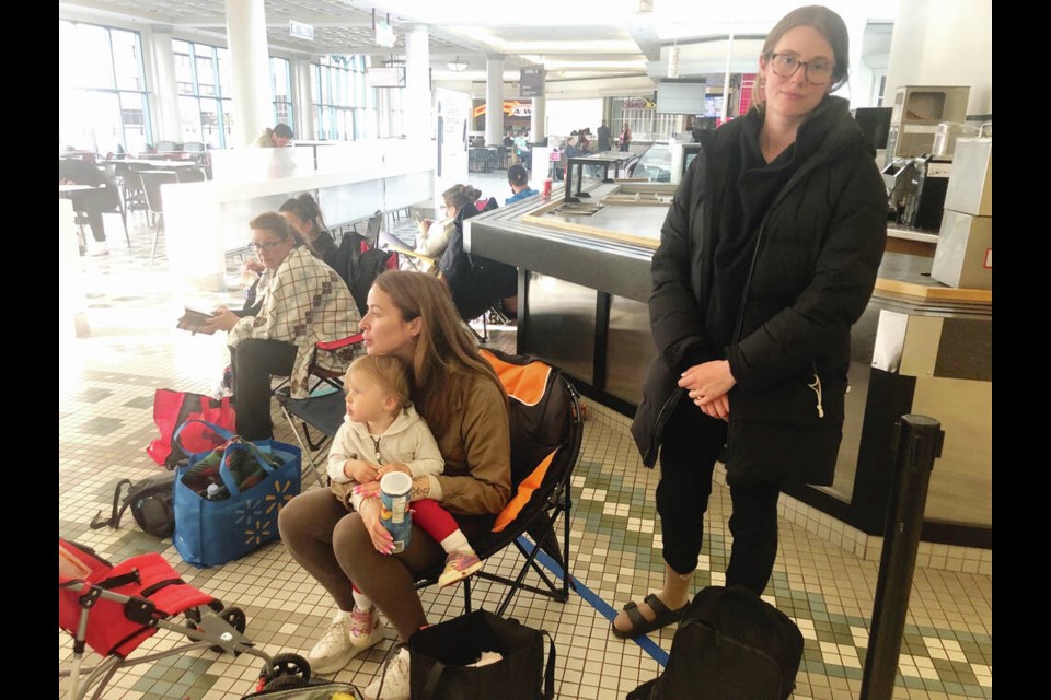 Clara Kucher lined up on Fort Street at 5 p.m. Thursday so she could be first when the 
Service Canada passport office opened at 8:30 a.m. Friday. Next in line is Karina Schulz of Ladysmith with 16-month-old Zafira.  In the photo, they're outside the passport office in the Bay Centre food court.   TIMES COLONIST 