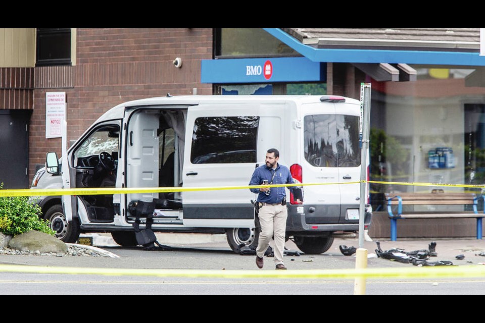 Police officers continued to comb through the crime scene Wednesday, one day after a bank robbery and fatal shootout at Shelbourne and Pear streets in Saanich. DARREN STONE, TIMES COLONIST 