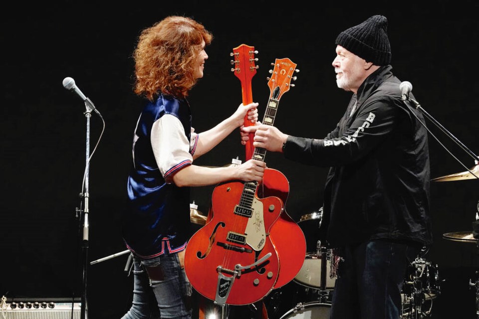 Rock legend Randy Bachman, right, and Japanese musician Takeshi exchange Gretsch guitars during a performance at the Canadian Embassy in Tokyo on Friday. Right: A still photo from a 1976 video on YouTube that was used to find Bachman's missing guitar. 	EUGENE HOSHIKO, THE ASSOCIATED PRESS 