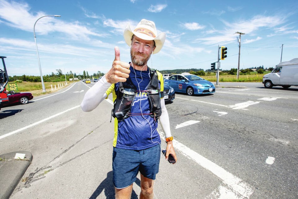 Dave Proctor, a 41-year-old massage therapist from Okotoks, Alta., gives a thumbs up on the Pat Bay Highway near Mount Newton Cross Road Thursday after running from St. Johns, Nfld. in 67 days and 10 hours. Story, page A3 DARREN STONE, TIMES COLONIST 