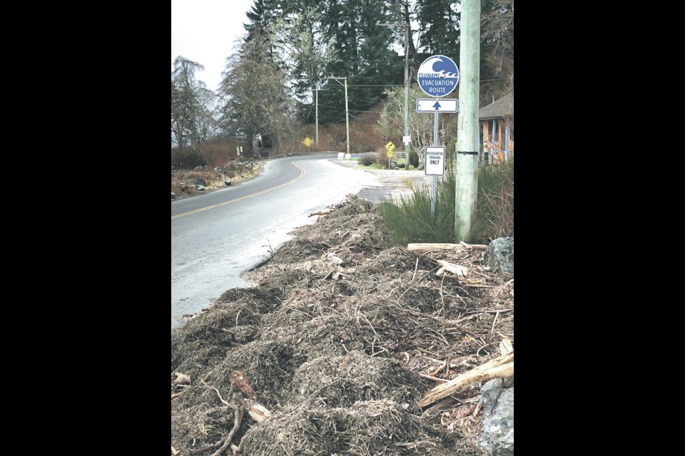 Ocean debris is cleared from the roadside after high tides and waves covered the roadside in the Jordan River area in January 2021. TIMES COLONIST