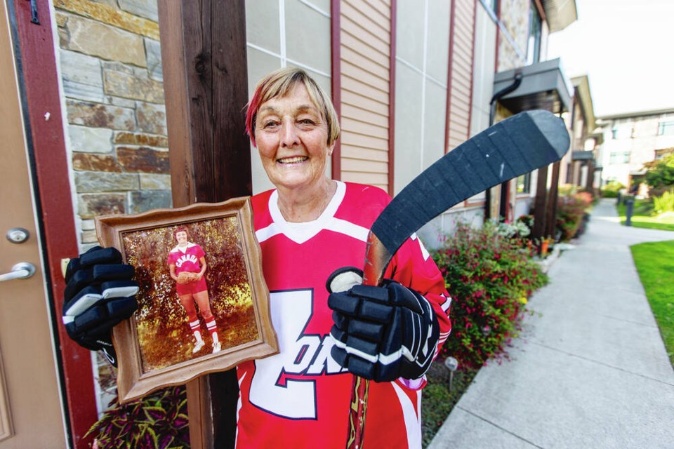 Irene Wallace, a 73-year-old member of the Boomer Babes, holds a picture of herself in 1979 when she played for Canada in fastpitch softball during the Pan Am Games. DARREN STONE, TIMES COLONIST 