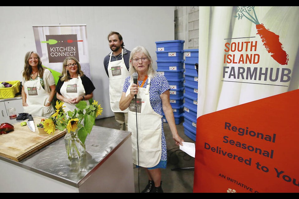 Susan Tychie speaks about the Kitchen Connect Food Hub processing program watched by, from left, Linda Geggie of the Victoria Community Food Hub, Minister of Agriculture Lana Popham and Ty James of Eat Island Grown. ADRIAN LAM, TIMES COLONIST 
